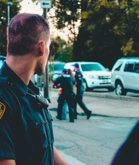 a police officer watching an ongoing arrest