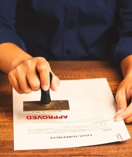 Businessman stamped the approved document while sitting at the table in the office