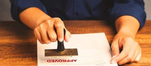 Businessman stamped the approved document while sitting at the table in the office