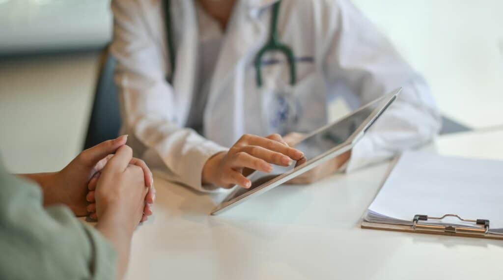 A doctor showing diagnosis in a table to a patient