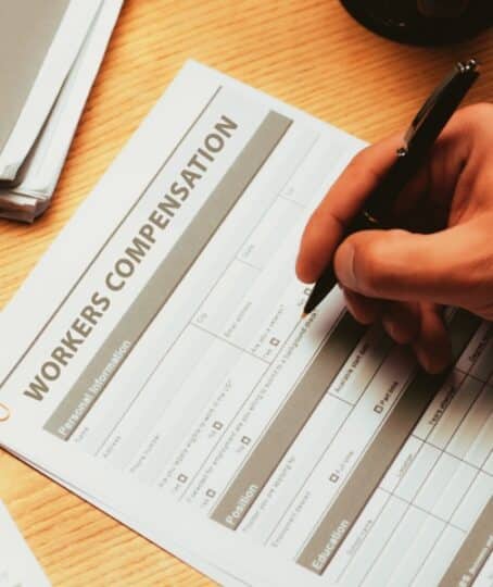 cropped view of man filling in Workers Compensation Accident Injury Concept