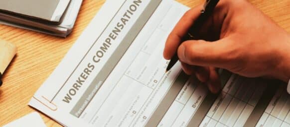 cropped view of man filling in Workers Compensation Accident Injury Concept