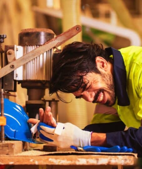 Engineer men wearing uniform accident on machines from work in lathe factory. health and safety concept standards. Helpful and Safety first.