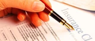 hand filling in insurance claim form. third-party insurance claims