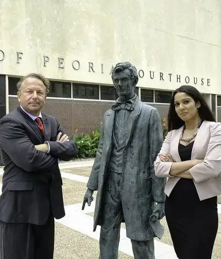 Todd Strong and Hania Sohail next to statue of Abe Lincoln outside Peoria courthouse