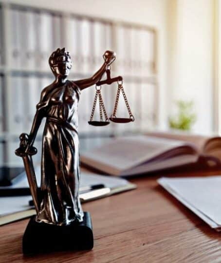 Lady Justice statue in law firm attorney office, blindfolded Justitia with balance scales and sword is personification of moral force in judicial system