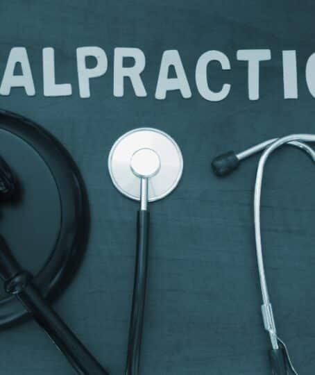 Wooden judge gavel and stethoscope on table, malpractice concept