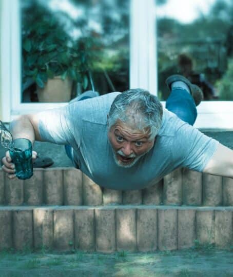 An older man has stumbled and falls down a flight of stairs.