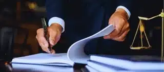 Close up lawyer businessman working or reading lawbook in office workplace. comparative fault vs contributory negligence