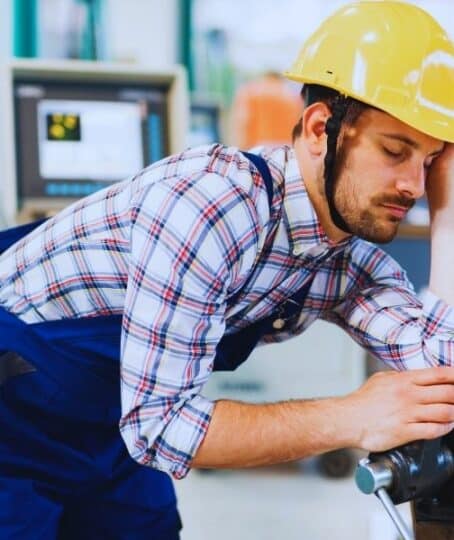 Tired overworked worker during working hours in factory. Mistakes that hurt a workers' comp claim