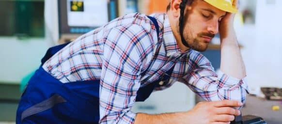 Tired overworked worker during working hours in factory. Mistakes that hurt a workers' comp claim