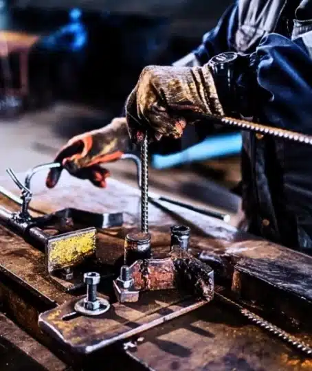 Close up shot of metallurgy worker's hands doing metal works.