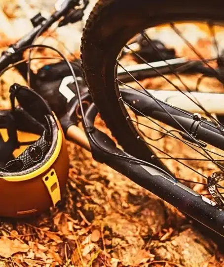 Bicycle accident with helmet on the ground with leaves and stones.