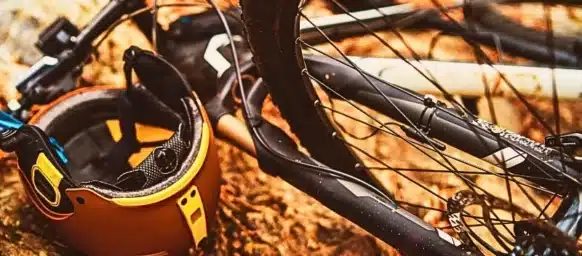 Bicycle accident with helmet on the ground with leaves and stones.