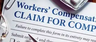 Workers' Compensation form with pen and glasses. employer doesn't carry workers' compensation insurance