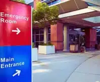 Main Entrance Of Modern Hospital Building With Signs.