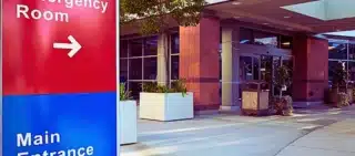 Main Entrance Of Modern Hospital Building With Signs.