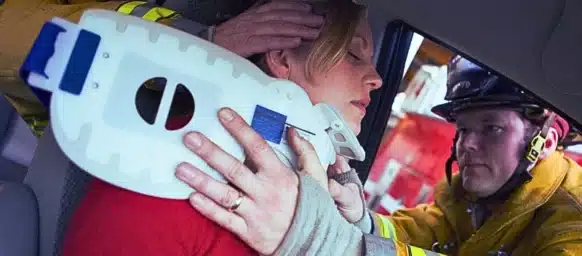 Paramedic assisting a woman from a car crash putting a neck brace. Car Accident While Working