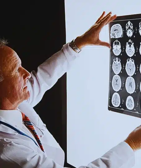 Doctor looks at brain scan images on light box. Concussions in the Workplace