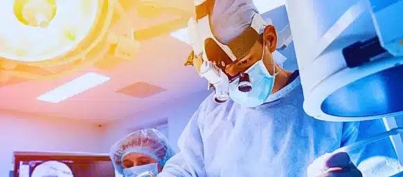 Group of surgeons in operating room with surgery equipment.