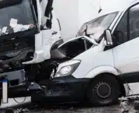 A van and a truck badly damaged in a head-on collision.