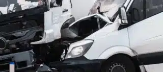 A van and a truck badly damaged in a head-on collision.