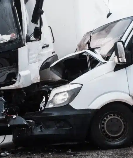 A van and a truck badly damaged in a head-on collision.