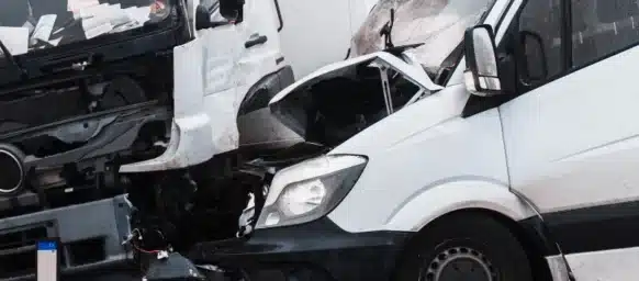 A van and a truck badly damaged in a head-on collision.