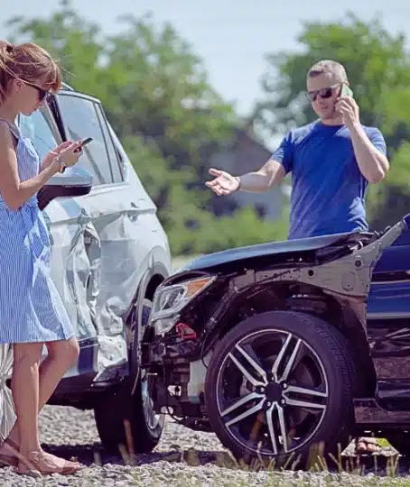 Aftermath of a minor two-car collision, where the drivers are handling the situation and reporting the accident. What Happens If the At-Fault Driver Has Only Minimum Insurance in Illinois
