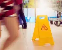 Yellow wet floor caution sign in public area. sue Walmart for a slip and fall