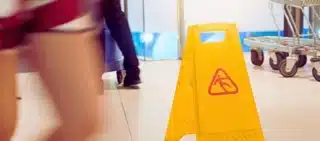 Yellow wet floor caution sign in public area. sue Walmart for a slip and fall