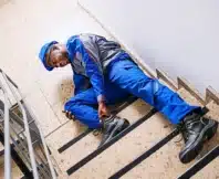 Injured worker in blue uniform fallen on stairs. injured on a job site that isn't your employer's