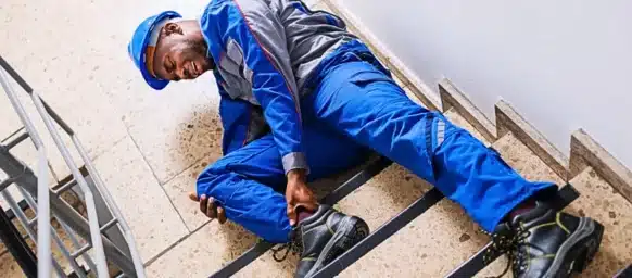 Injured worker in blue uniform fallen on stairs. injured on a job site that isn't your employer's