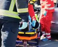 Emergency responders treating a patient on a stretcher.