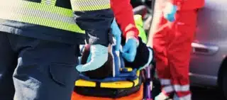 Emergency responders treating a patient on a stretcher.