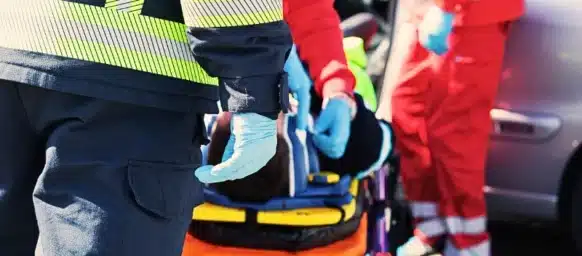 Emergency responders treating a patient on a stretcher.