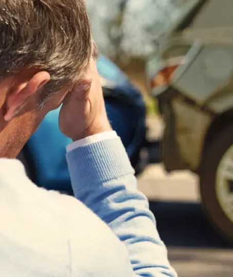 A man sits looking worried because he has just crashed into another car insurance company blames you for the accident
